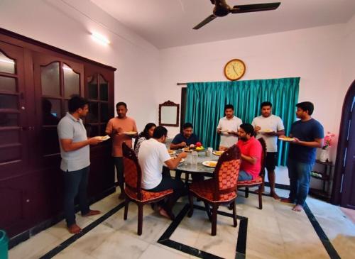 PūrnānkuppamCeleste Luxury Bungalow的一群人站在一个房间里桌子旁