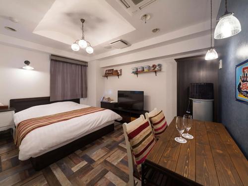 a bedroom with a bed and a table with a dining room at Hotel Charmies Meito - Adult Only in Nagoya