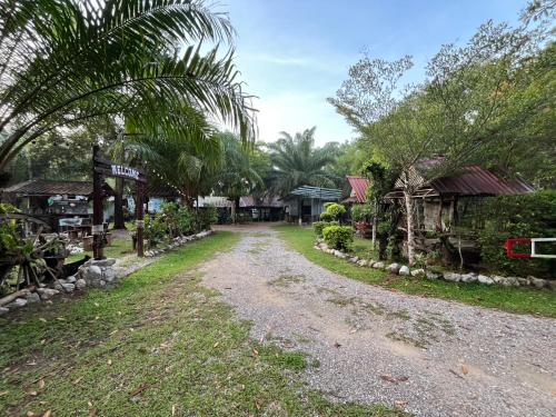a dirt road through a village with houses at สบายคันทรีรีสอร์ท ปากเมงSa-buy country resort Pak Meng in Sikao