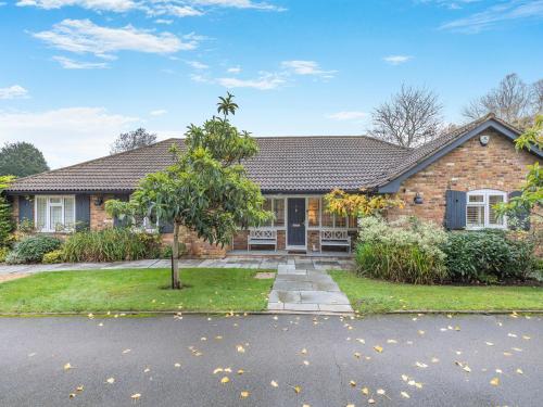 ein Backsteinhaus mit einem Baum im Vorgarten in der Unterkunft Longways in Penn