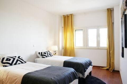a bedroom with two beds and a window at Parque das Nações - Fil New Apartment in Lisbon