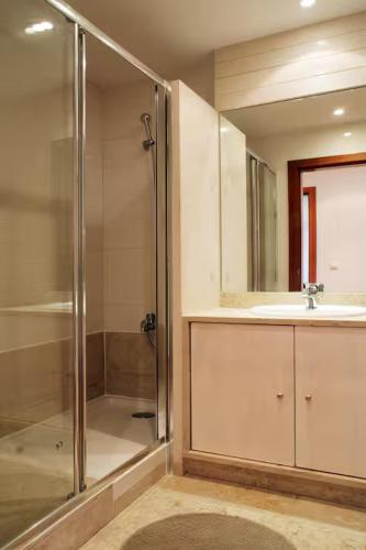 a bathroom with a shower and a sink and a mirror at Parque das Nações - Fil New Apartment in Lisbon