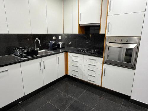 a kitchen with white cabinets and stainless steel appliances at Parque das Nações - Fil New Apartment in Lisbon
