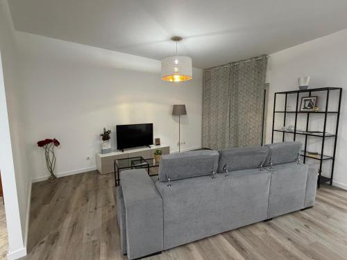 a living room with a couch and a tv at Parque das Nações - Fil New Apartment in Lisbon