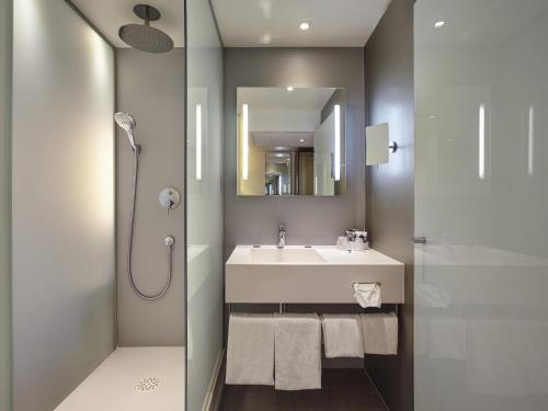 a bathroom with a sink and a shower at Mercure Paris Arc de Triomphe Etoile in Paris