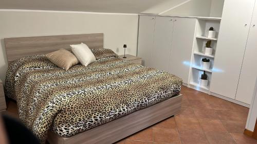a bedroom with a bed with a leopard print blanket at Eden Apartment di Manenti Andrea in Oltre il Colle