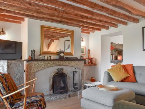 a living room with a fireplace and a couch at Rivendell Cottage in Liskeard