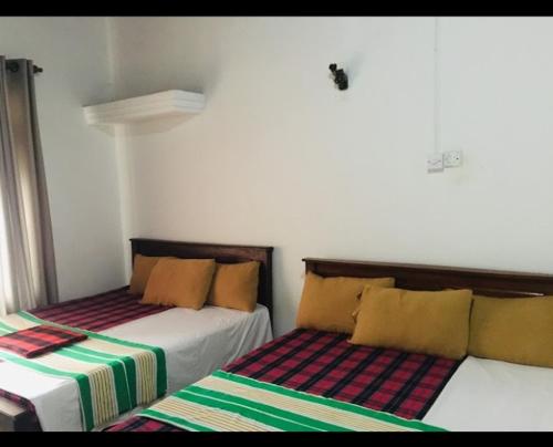 Dos camas una al lado de la otra en una habitación. en NK Hotel & Resturaunt, en Matale