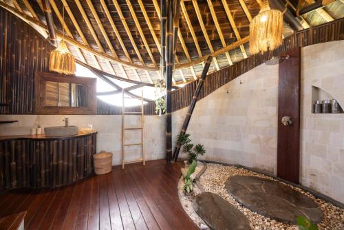 a bathroom with a sink and a wooden floor at Ketanu Bamboo Lodge Sumba in Praikalogu