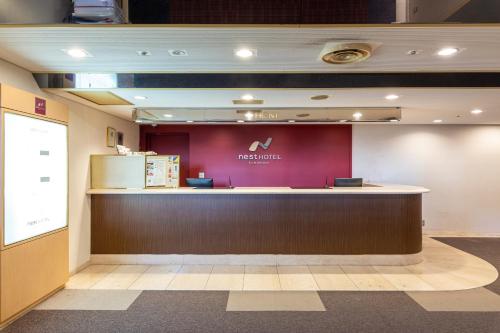 um saguão com um balcão com uma placa da Apple em Nest Hotel Kumamoto em Kumamoto