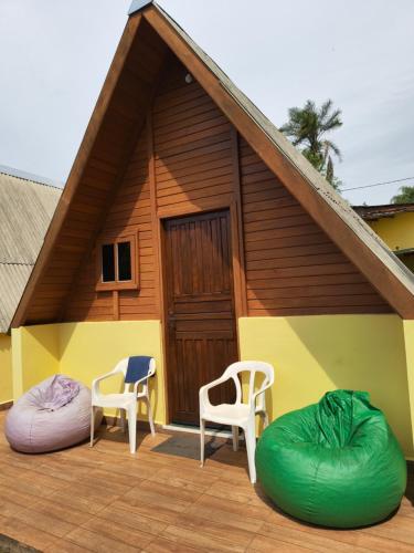 una casa con dos sillas y un edificio con un porche en Chalés Magia das Águas, en Águas de Lindóia