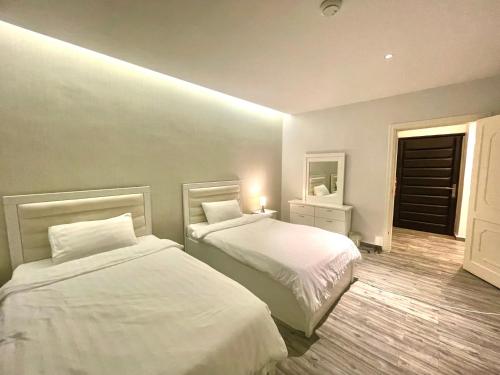 a bedroom with two beds and a mirror at شقة 9 in Al-Safa