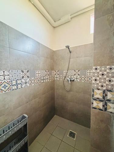 a bathroom with a shower with tiles on the wall at Sunrise Camp in Mirleft