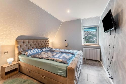 a bedroom with a bed and a tv on the wall at Fewo Lütt Stuv in Fockbek