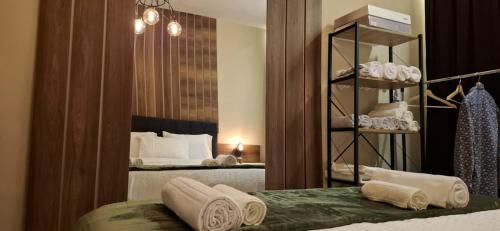 a bedroom with two beds and a mirror with towels at Grand Albi Apartament in Gjakove