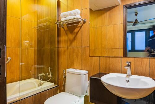 une salle de bain avec toilettes, lavabo et baignoire dans l'établissement Coral Grand Beach & Spa, à Hulhumalé