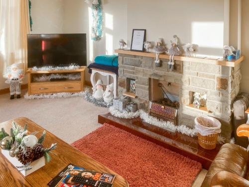 a living room with a fireplace and a tv at Ivy Grange Cottage in Wistow