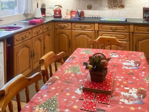 a kitchen with a table with a christmas table cloth at Ivy Grange Cottage in Wistow