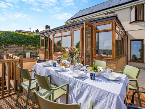 a table with a white table cloth on a patio at Halfstone House in Llanelli