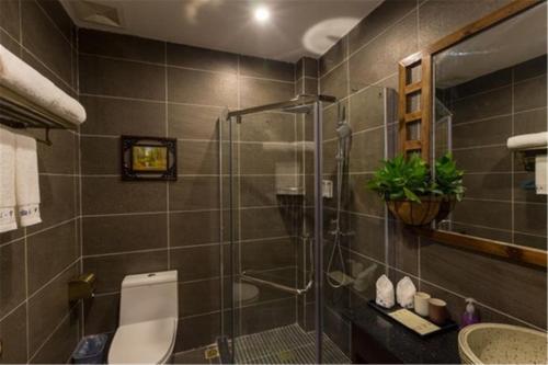 a bathroom with a shower and a toilet and a sink at Guilin cozy mountain retreat in Guilin