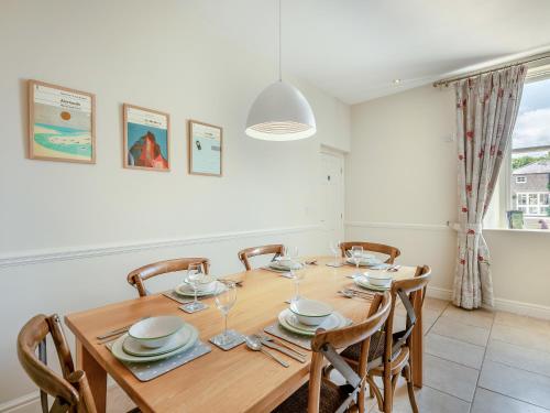 ein Esszimmer mit einem Holztisch und Stühlen in der Unterkunft Swinney Cottage - Uk49893 in Preston