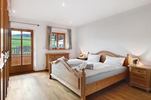 a bedroom with a wooden bed and a window at Ferienhaus Region Tegernsee in Eben