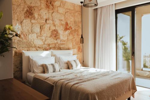 a bedroom with a large bed with a stone wall at Orama Luxury Villa 4 Bedrooms with Private Pool in Hersonissos