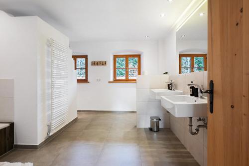 a bathroom with two sinks and two mirrors at Ferienhaus Region Tegernsee in Eben