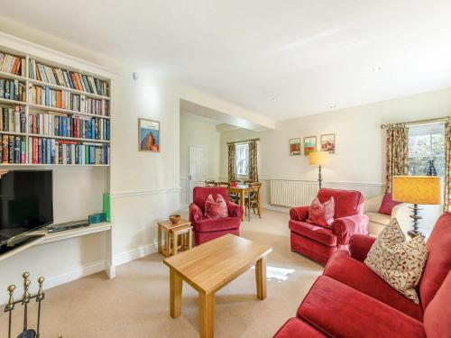 a living room with red chairs and a tv at Longlands - Uk49289 in Preston