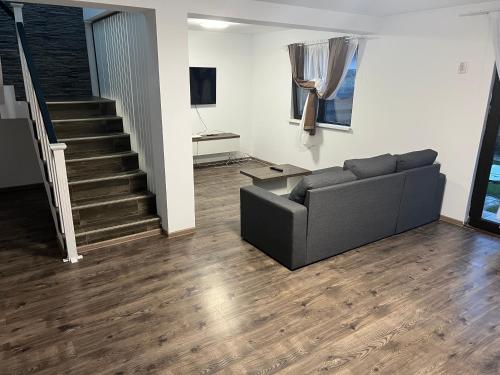 a living room with a couch and a staircase at Villa59 in Preajba
