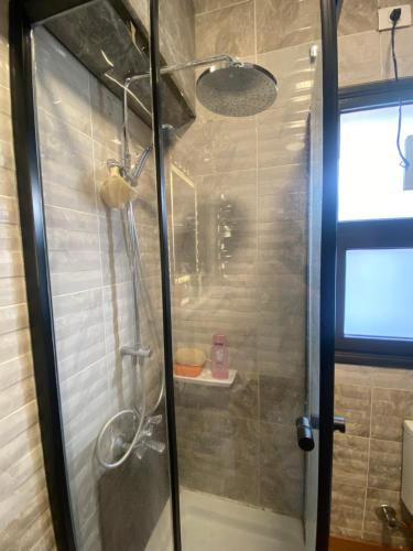 a shower with a glass door in a bathroom at Mango in Madinaty