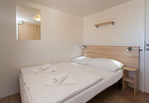 a room with a bed with two towels on it at Valamar Camping Lanterna - Adriacamps in Poreč