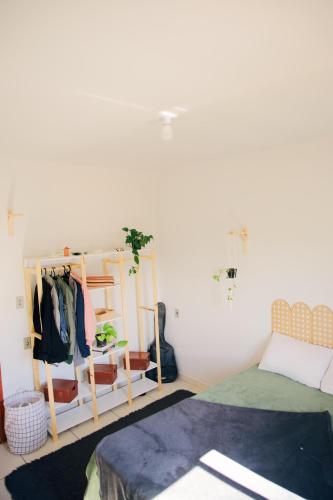 1 dormitorio con 1 cama y perchero en Casa Dengo - Quarto Aconchegante, en Ouro Preto