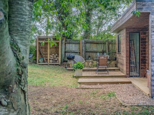a backyard with a wooden fence and a patio with chairs at The Lodge In The Woods in Raithby