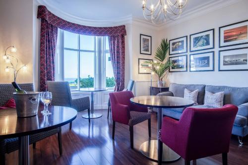 a living room with tables and chairs and a window at The Helaina in Scarborough