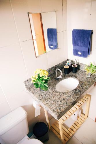 Un baño con lavabo, inodoro y espejo. en Casa Dengo - Quarto Aconchegante, en Ouro Preto