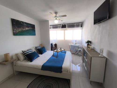 a bedroom with a bed with blue pillows and a table at The beach nest in Candelaria