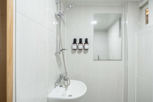 a white bathroom with a sink and a shower at stay105행궁 in Suwon