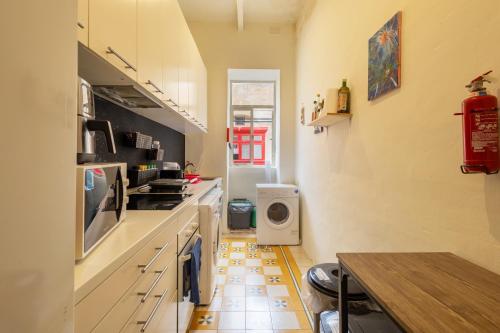 a small kitchen with a stove and a floor at Ensuite budget twin room at quiet and friendly townhouse in Sliema