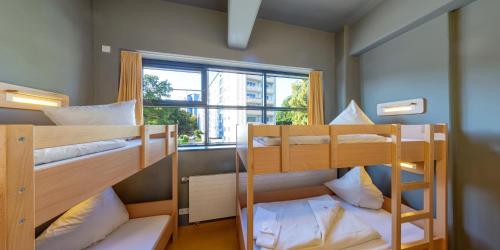 two bunk beds in a room with a window at DJH Jugendherberge Chemnitz "eins" in Chemnitz