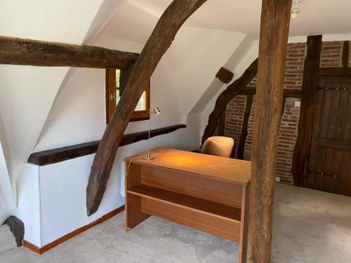 Chaumière 6-8p, 4ch, proche Honfleur في Conteville: مكتب خشبي في غرفة ذات عوارض خشبية
