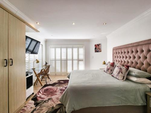 ein Schlafzimmer mit einem großen Bett mit großem Kopfteil in der Unterkunft Central Beach Stay Ultimate Holiday Spot in Jeffreys Bay