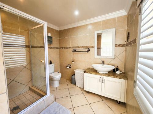 ein Badezimmer mit Dusche, Waschbecken und Toilette in der Unterkunft Central Beach Stay Ultimate Holiday Spot in Jeffreys Bay