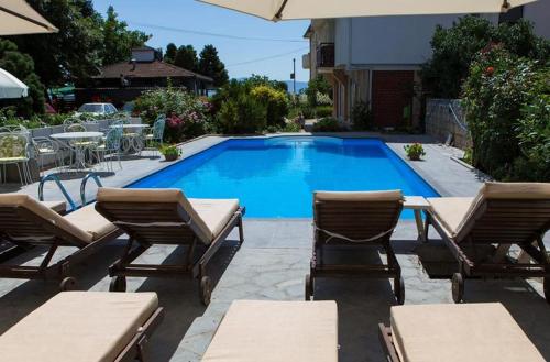 a swimming pool with two chairs and a table at Villa Jordan in Ohrid