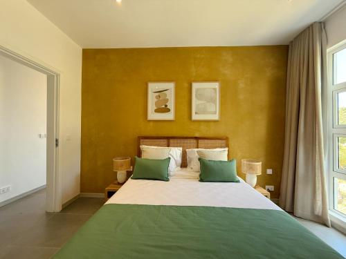 a bedroom with a large bed with two green pillows at Lorlagon by LOV Mauritius in Trou dʼ Eau Douce