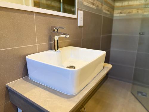 a bathroom with a white sink and a shower at Lorlagon by LOV Mauritius in Trou dʼ Eau Douce