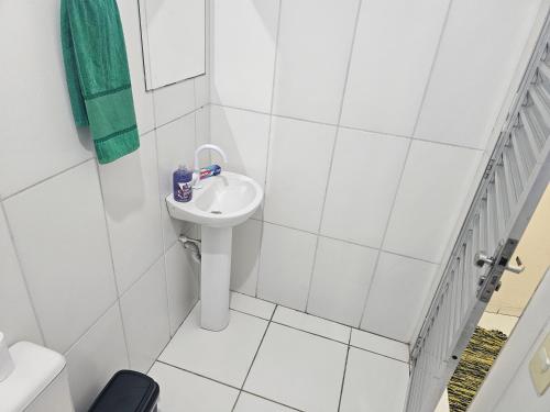 a white bathroom with a sink and a toilet at Itapecerica da Serra perto de Embu das artes e Cotia in Itapecerica da Serra