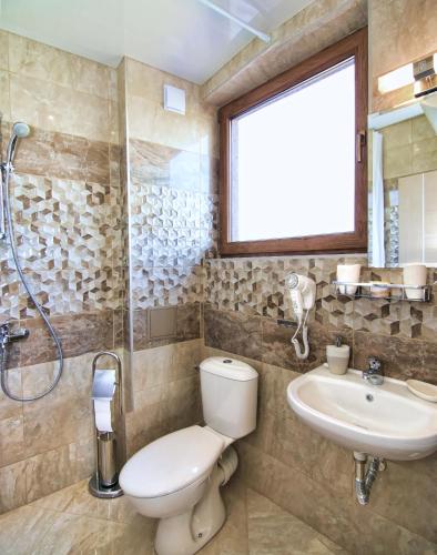 a bathroom with a toilet and a sink at Eco House Kitana in Asparukhovo