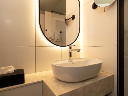 a bathroom with a sink and a mirror at Campanile Hotel & Restaurant Breda in Breda
