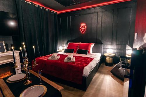 - une chambre avec un lit doté d'oreillers rouges et une cheminée dans l'établissement Love room - Le secret du marquis, à Provins